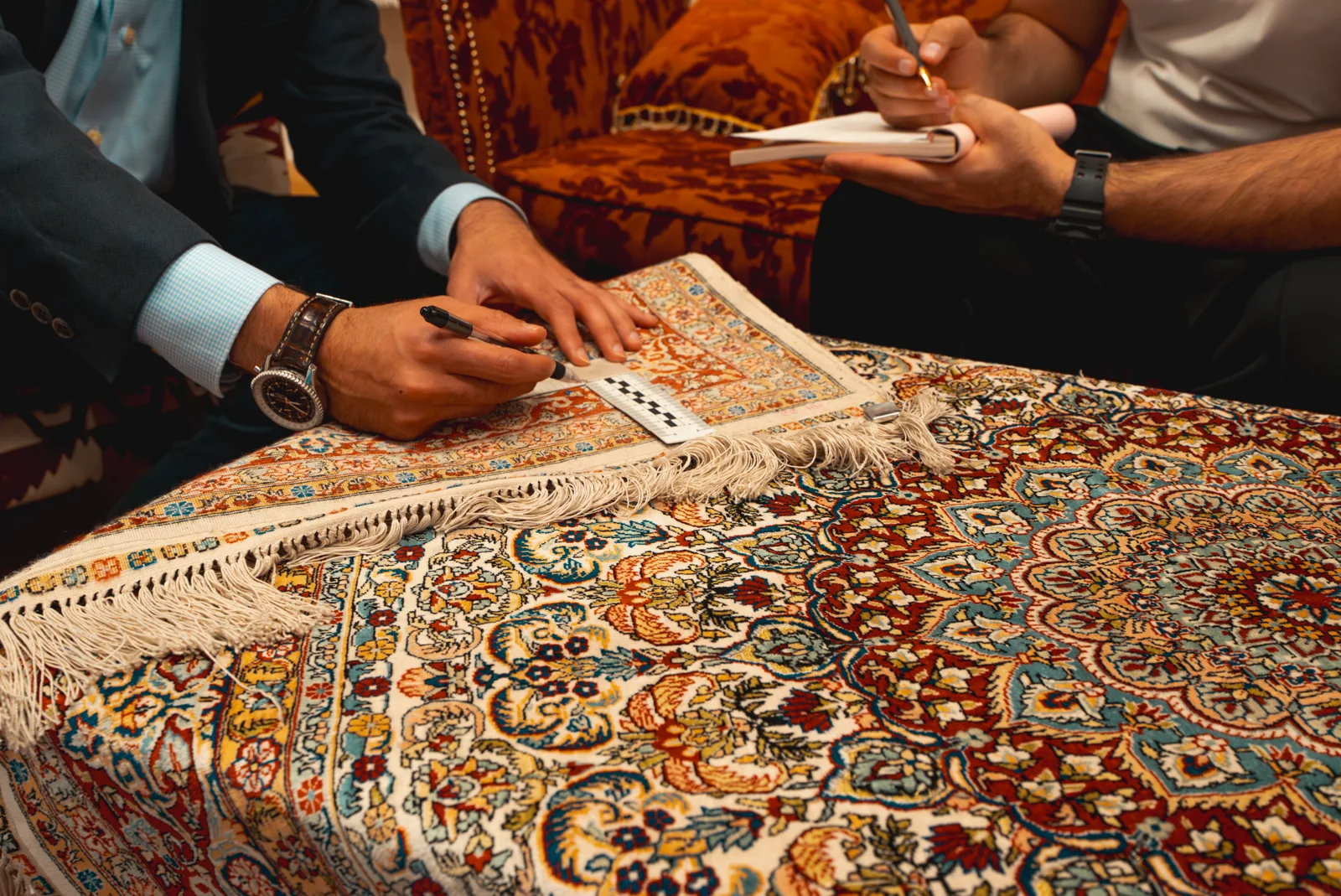A rug being examined by hand in the showroom